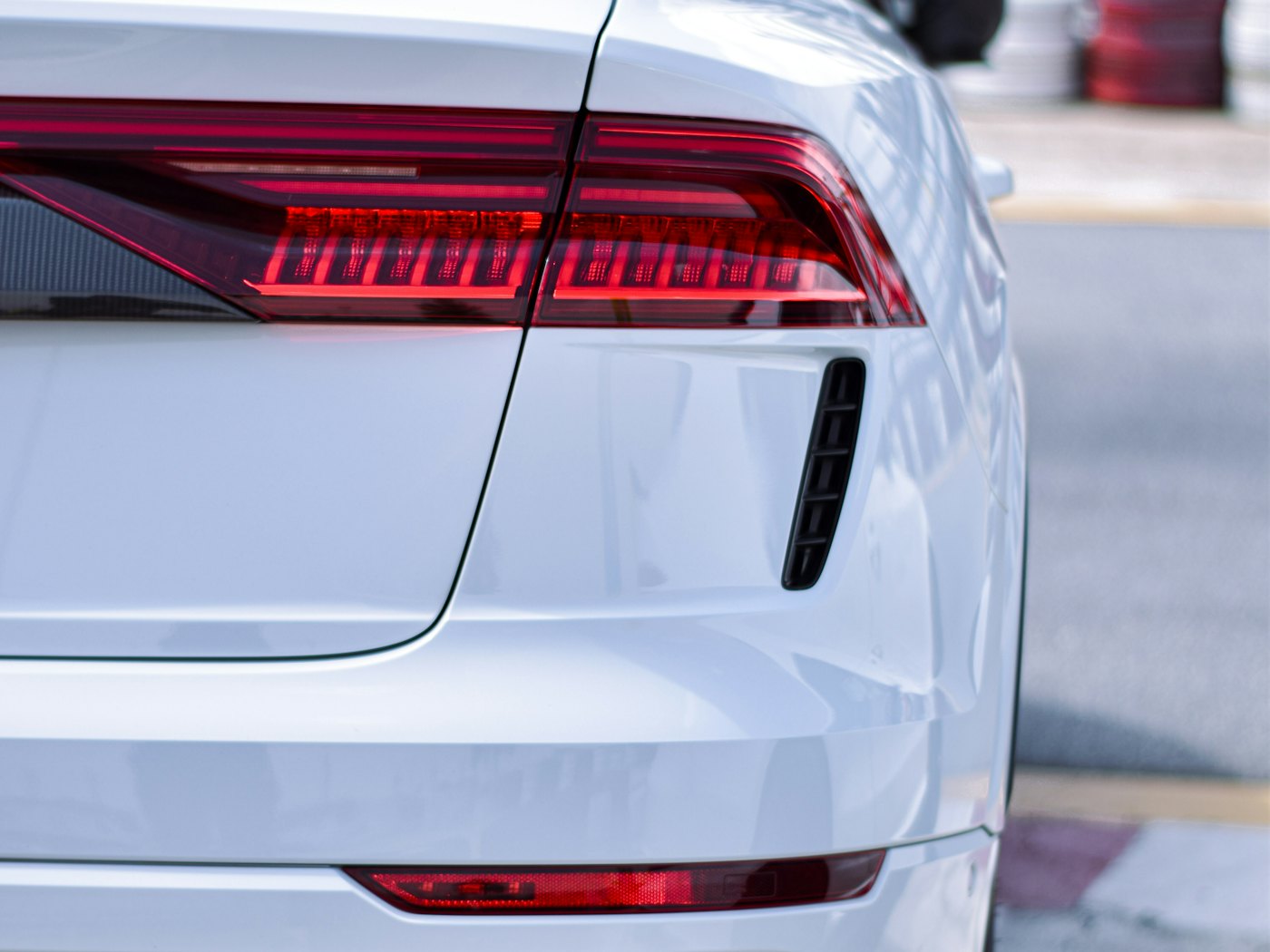 Rear quarter of a white saloon, tail light detail